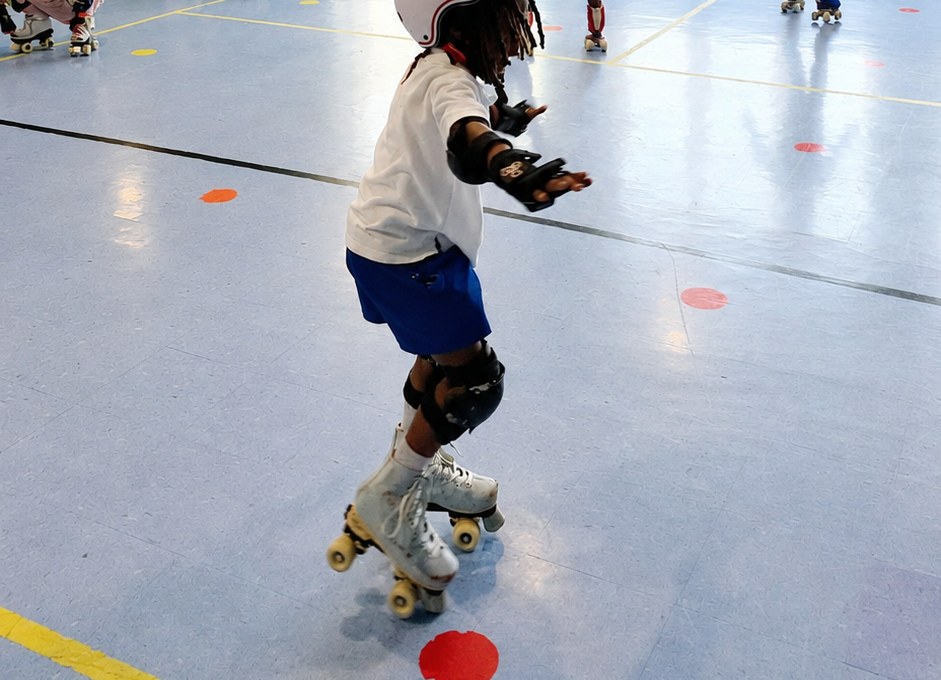 Student actively roller skating in a school gymnasium