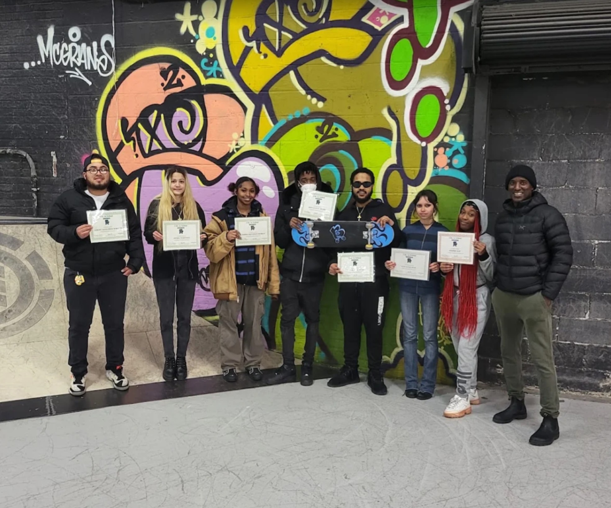 Blue Skate interns holding their City-As-School completion certificates at a skate park
