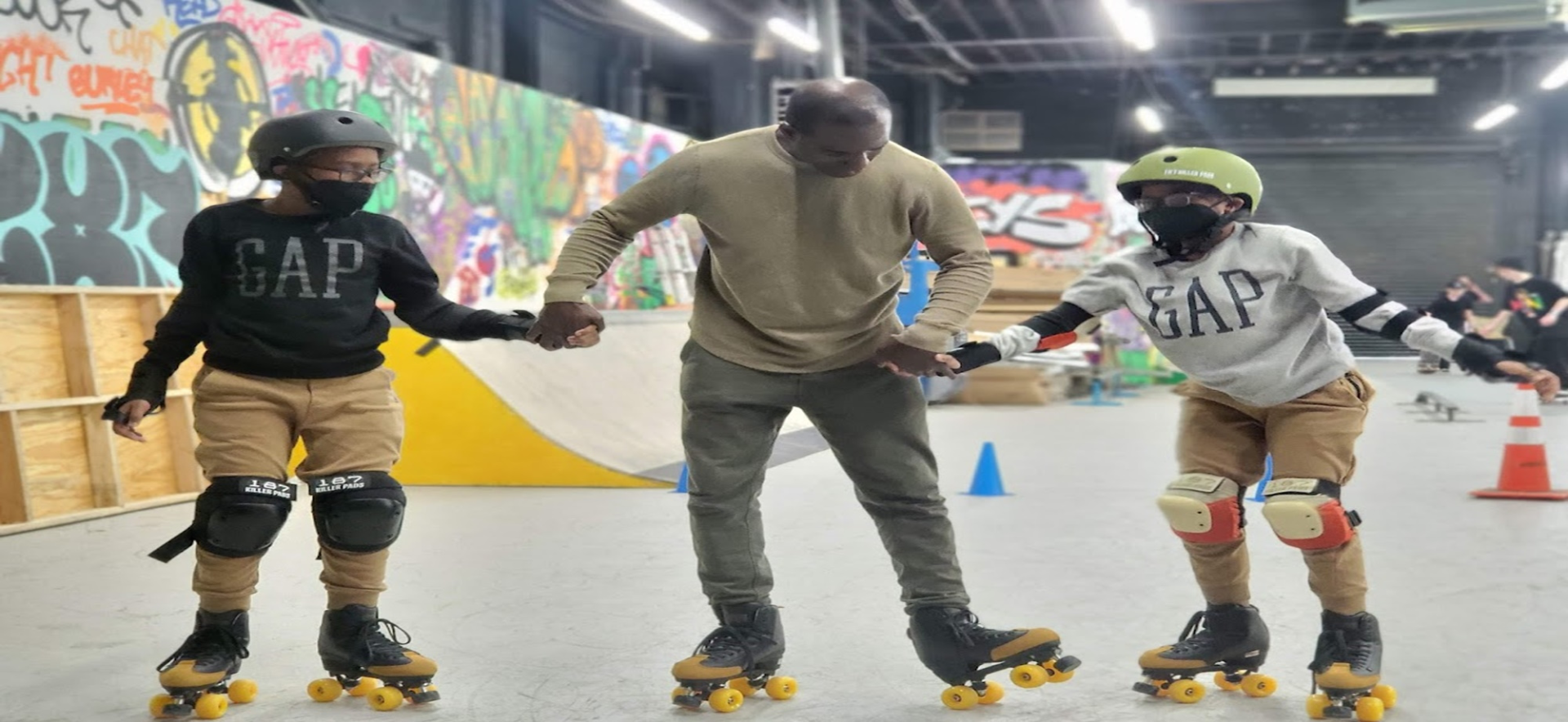David Isaac coaching skaters at an indoor rink